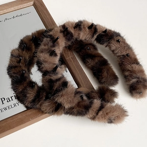 Macro detail of leopard print plush headband featuring non-slip inner teeth and soft fur texture