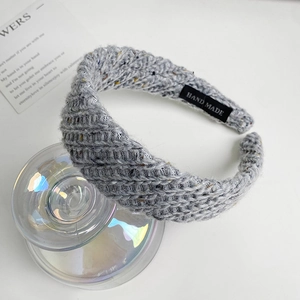 Detail of grey knitted headband with silver sequins and hand made label tag