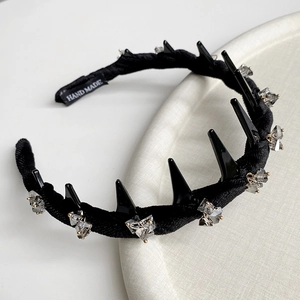 Detailed macro view showing the HAND MADE label and crystal studs on a velvet headband