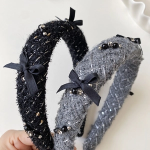 Detail of tweed headband with black bow, pearls and rhinestones in grey and black