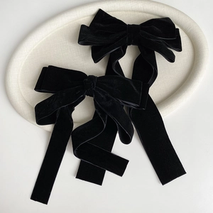 Elegant black velvet bow hair clips set of two on a beige tray for vintage styling