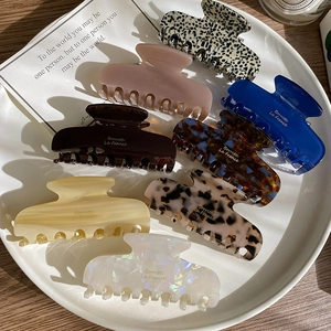 Detail view of acetate hair claws in various marble and solid colors for French styling