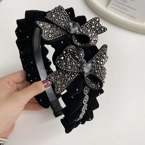 Elegant black velvet headband with pleated texture and rhinestone heart bow details