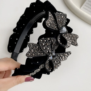 Detailed view of luxury velvet headband with pleated edges and crystal-encrusted bows