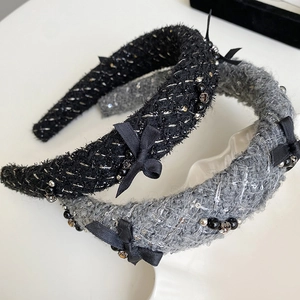 Detailed shot of two vintage tweed headbands with silk bows and elegant bead accents