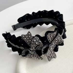 Macro detail of velvet bow headband with sparkling crystals and heart-shaped gemstones