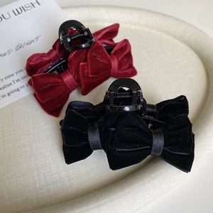 Detailed view of elegant velvet bow hair claws in burgundy and classic black colors