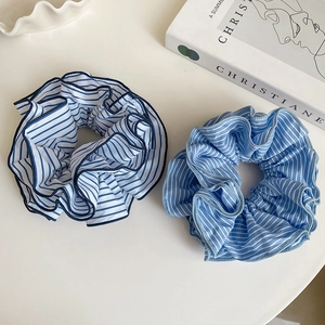 Close-up of blue and white striped fabric scrunchies with elegant pleated texture