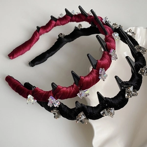 Detail view of velvet wavy headbands with black spikes and crystals in red and black colors