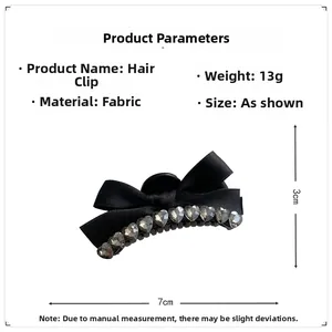 Detail view of black ribbon bow hair claw clip with heart-shaped rhinestones and 7cm size info