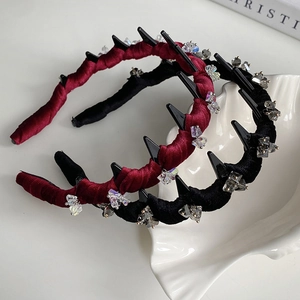 Detail of velvet wavy headbands in wine red and black with crystal accents and teeth