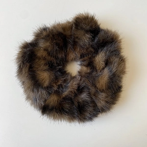 Gros plan sur un chouchou en fausse fourrure marron montrant sa texture douce et pelucheuse