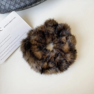 Gros plan sur chouchou en peluche léopard avec texture fausse fourrure douce sur un sac