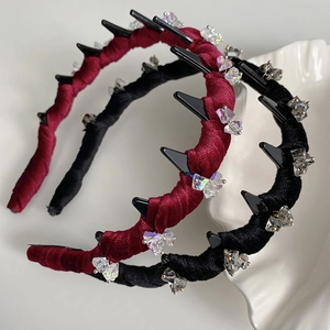 Close-up of velvet wavy headbands with sparkling crystal bows in red and black colors