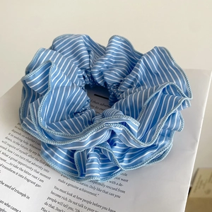 Blue and white striped fabric scrunchie with a stylish wavy pleated texture