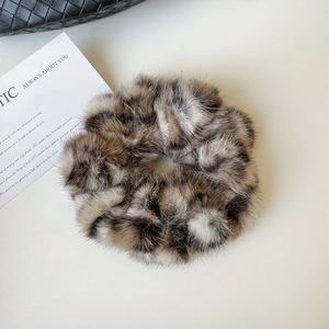 Détail d'un chouchou léopard en peluche montrant la texture douce de la fausse fourrure