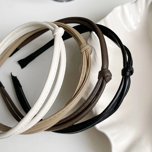 Close-up of knotted leather headbands in cream, khaki, brown and black colors