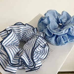 Detail shot of striped oversized scrunchies in blue and navy on a book background