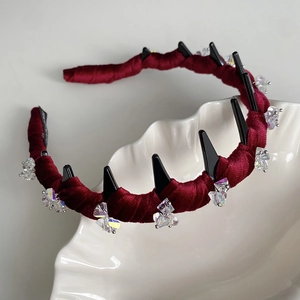 Close-up of a burgundy velvet headband featuring non-slip teeth and sparkling crystals