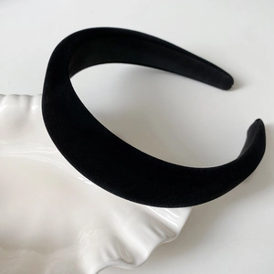 Vue détaillée du serre-tête en velours noir sur une assiette en céramique blanche