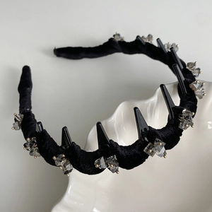 Detail view of black velvet headband with teeth and grey crystal embellishments