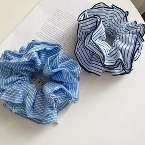 Striped fabric scrunchies in light and dark blue with wavy edges for hair styling