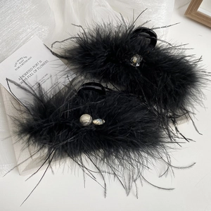 Close-up of black feather hair claw clip with faux pearls and square crystals details