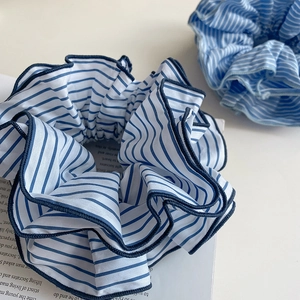 Detail of blue and white striped fabric scrunchies with fine stitching and soft texture