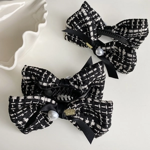 Elegant black and white tweed bow hair clips with pearls and gold metal accents