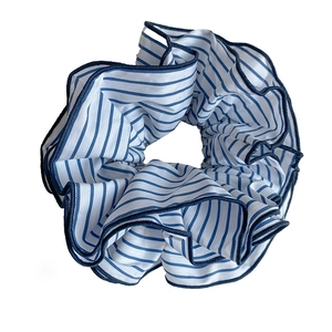 Blue and white striped fabric scrunchie with dark blue stitched edges on white background