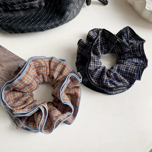 Close-up of four-layer plaid fabric scrunchies in navy and brown vintage patterns
