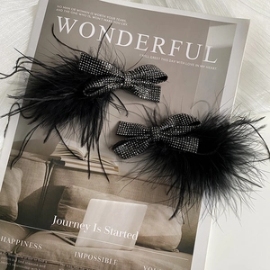 Sparkly black sequin bow hair clips with ostrich feathers on a vintage magazine base