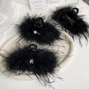 Detailed set of black feather hair claws with pearls, rhinestones, and glitter bow accents