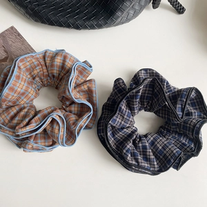 Close-up of four-layer plaid scrunchies in retro brown and dark blue vintage checkered patterns