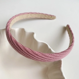 Gros plan du bandeau tricoté rose montrant la texture tissée et la doublure beige