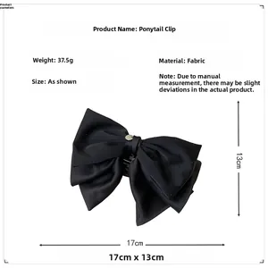 Détail d'une pince à cheveux nœud noir indiquant les dimensions de 17cm sur 13cm