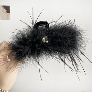 Close-up of fluffy black feather hair claw clip with a large rectangular grey gemstone
