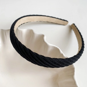 Détail d'un serre-tête tressé noir avec doublure antidérapante en velours beige et texture