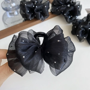 Detail of black mesh cloud bubble claw clip with silver rhinestones and vintage background