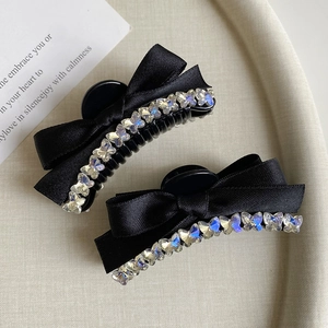 Detail of black ribbon bow hair claws with sparkling butterfly rhinestones set of two