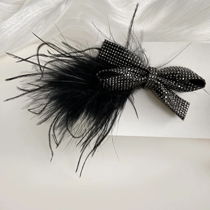 Macro shot of elegant black rhinestone bow hair clip with natural ostrich feathers