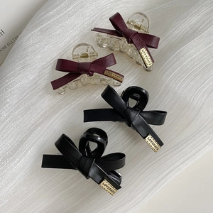Eleganti fermagli per capelli con fiocco in pelle bordeaux e nero e logo dorato