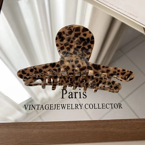 Macro view of French vintage leopard print hair claw with golden Barrette La France text