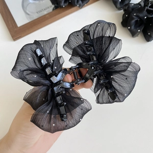 Close-up of black mesh cloud bubble claw clip with sparkling rhinestones and ribbon