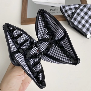 Macro view of a butterfly hair claw clip with black and white gingham fabric texture