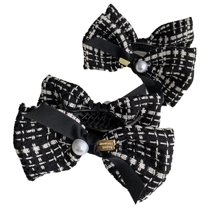 Elegant black and white tweed bow hair clips with pearl and gold metal brand accent