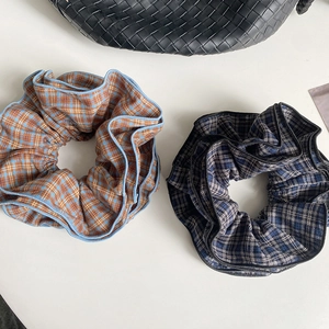 Detailed macro view of four-layer plaid hair scrunchies with vibrant checked patterns