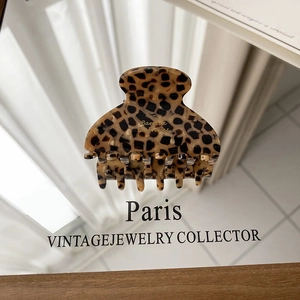 Detail of the golden Barrette La France text on a vintage leopard pattern hair claw clip
