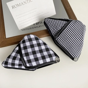 Detail of checkered triangle oven mitts with bow-engraved metal button decoration