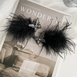 Close-up of black feather hair clips with sparkling rhinestone butterfly decoration